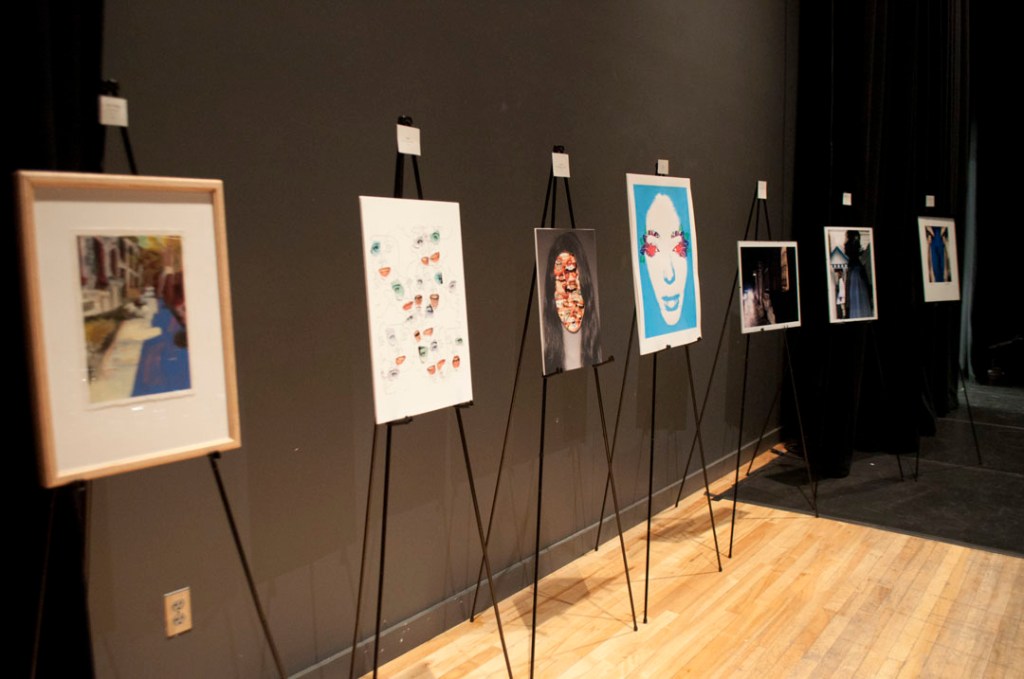 A row of easels featuring artwork by Lauren Bryant and other visual artists