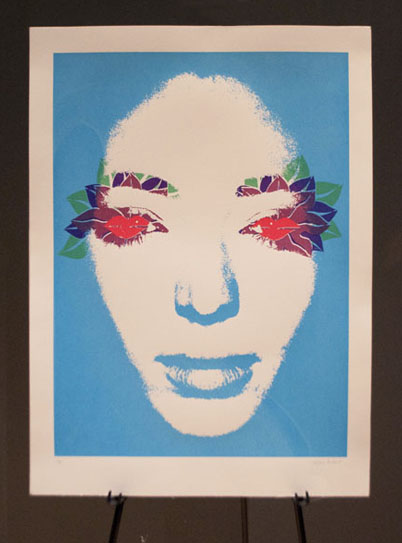Screenprint entitled "See" featuring a woman's face whose eyes have been replaced with a pattern of multi-color lips that form the shape of flower petals