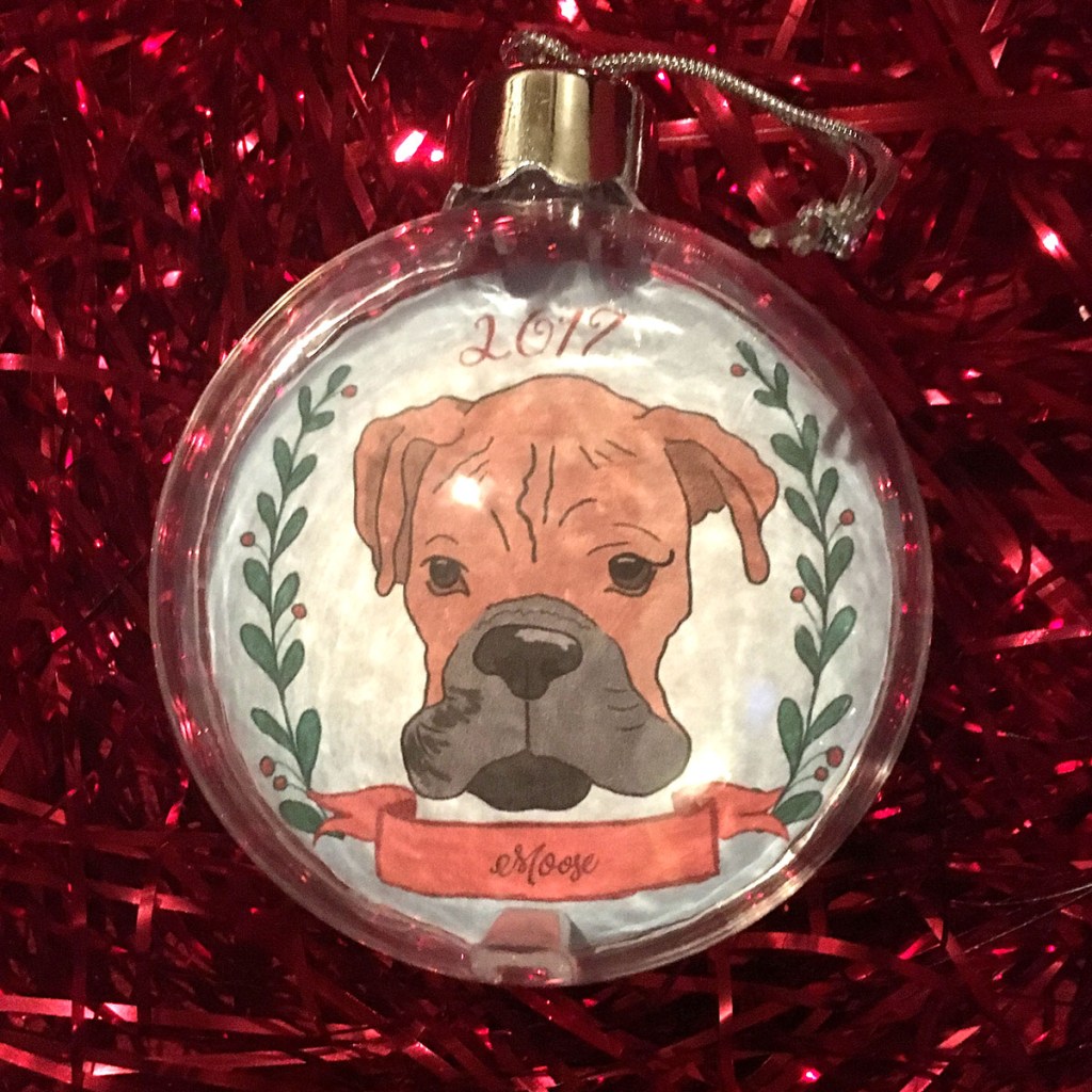 Holiday ornament with an illustrated portrait of a dog named Moose