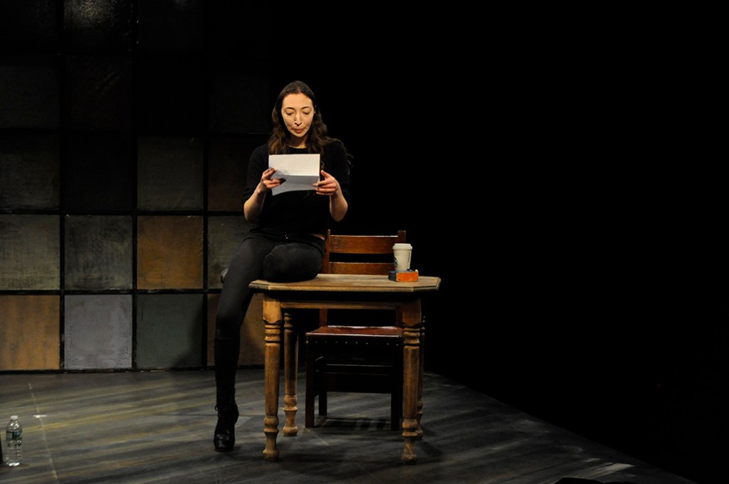 Arielle Beth Klein sitting on a table reading a letter in "My Shiksa Boyfriend." Photo by Lauren Bryant.