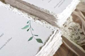 Stack of Wedding Invitations. Detail of watercolor leaves.