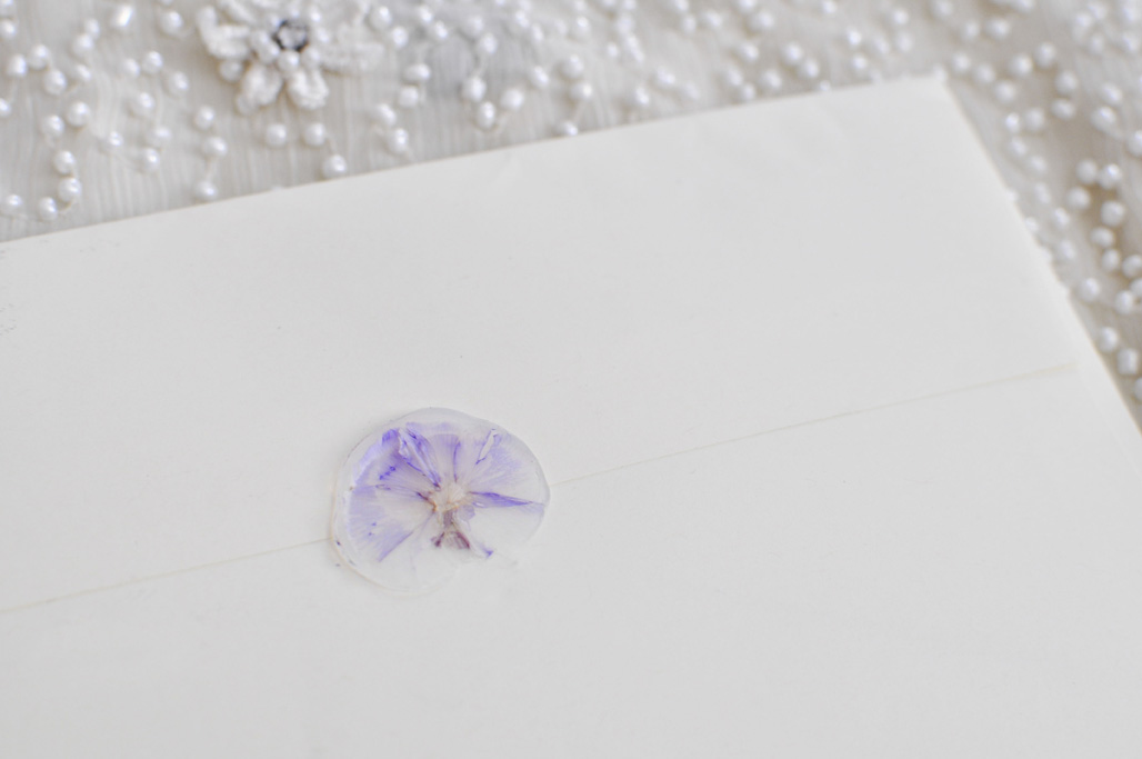 Stack of Wedding Invitations. Detail of wax seal.
