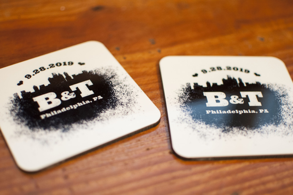 Two coasters with a spray paint design that features the Philadelphia skyline and reads 9.28.2019 B&T Philadelphia, PA