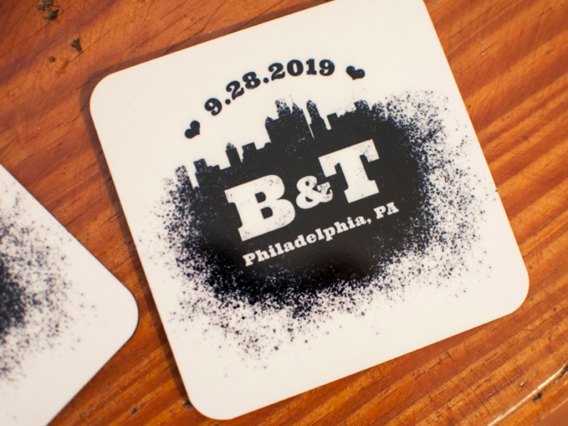 A coaster with a spray paint design that features the Philadelphia skyline and reads 9.28.2019 B&T Philadelphia, PA